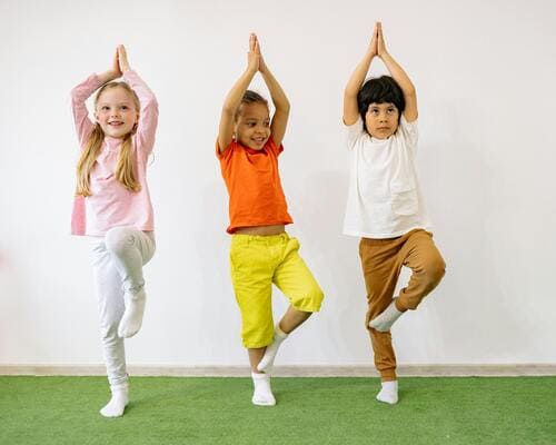 Enfants pratiquant un exercice de Brain Gym pour améliorer concentration et coordination.